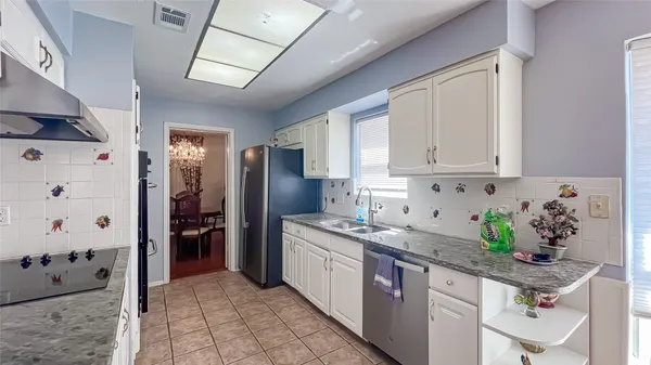 a kitchen with stainless steel appliances granite countertop a sink a stove a refrigerator and cabinets