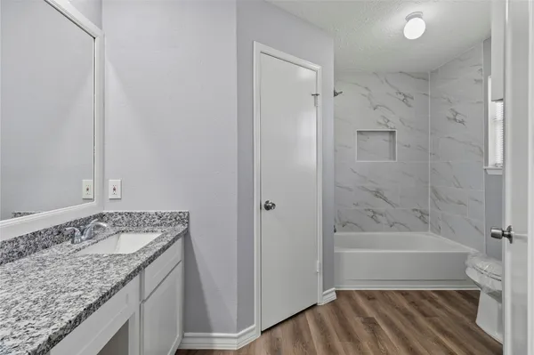 a bathroom with a granite countertop sink and a mirror
