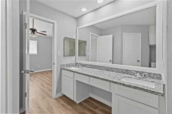 a bathroom with a granite countertop sink and a mirror