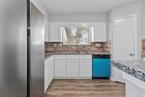 a kitchen with stainless steel appliances granite countertop a stove a sink and a refrigerator