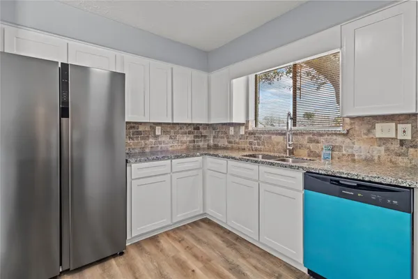 a kitchen with stainless steel appliances granite countertop a refrigerator sink and cabinets