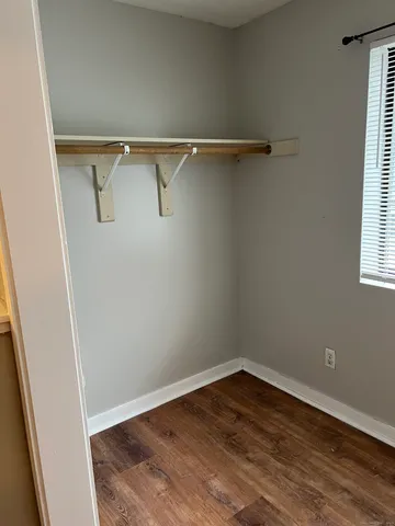 a view of a room with wooden floor and windows
