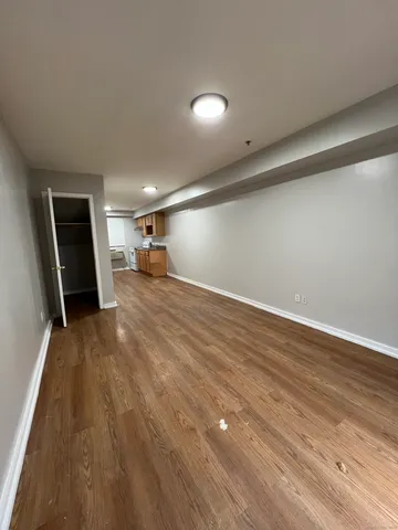a view of a room with wooden floor and a ceiling fan