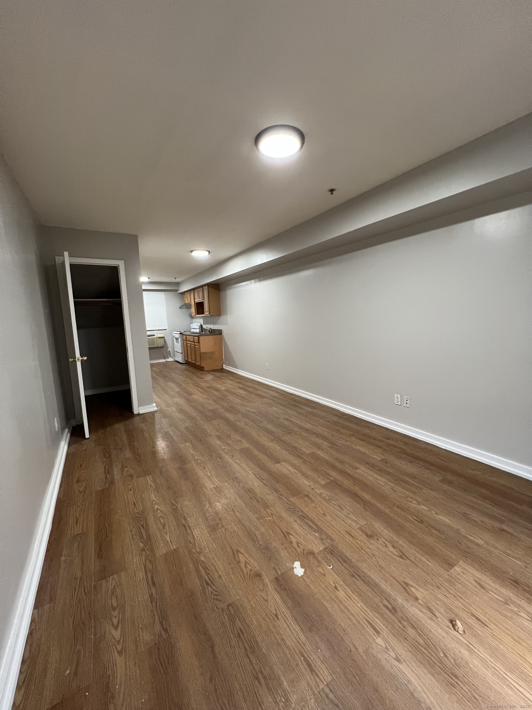 385 Putnam Avenue, Unit 35 Hamden, CT 06517 - Photo 2 of 17 a view of a room with wooden floor and a ceiling fan