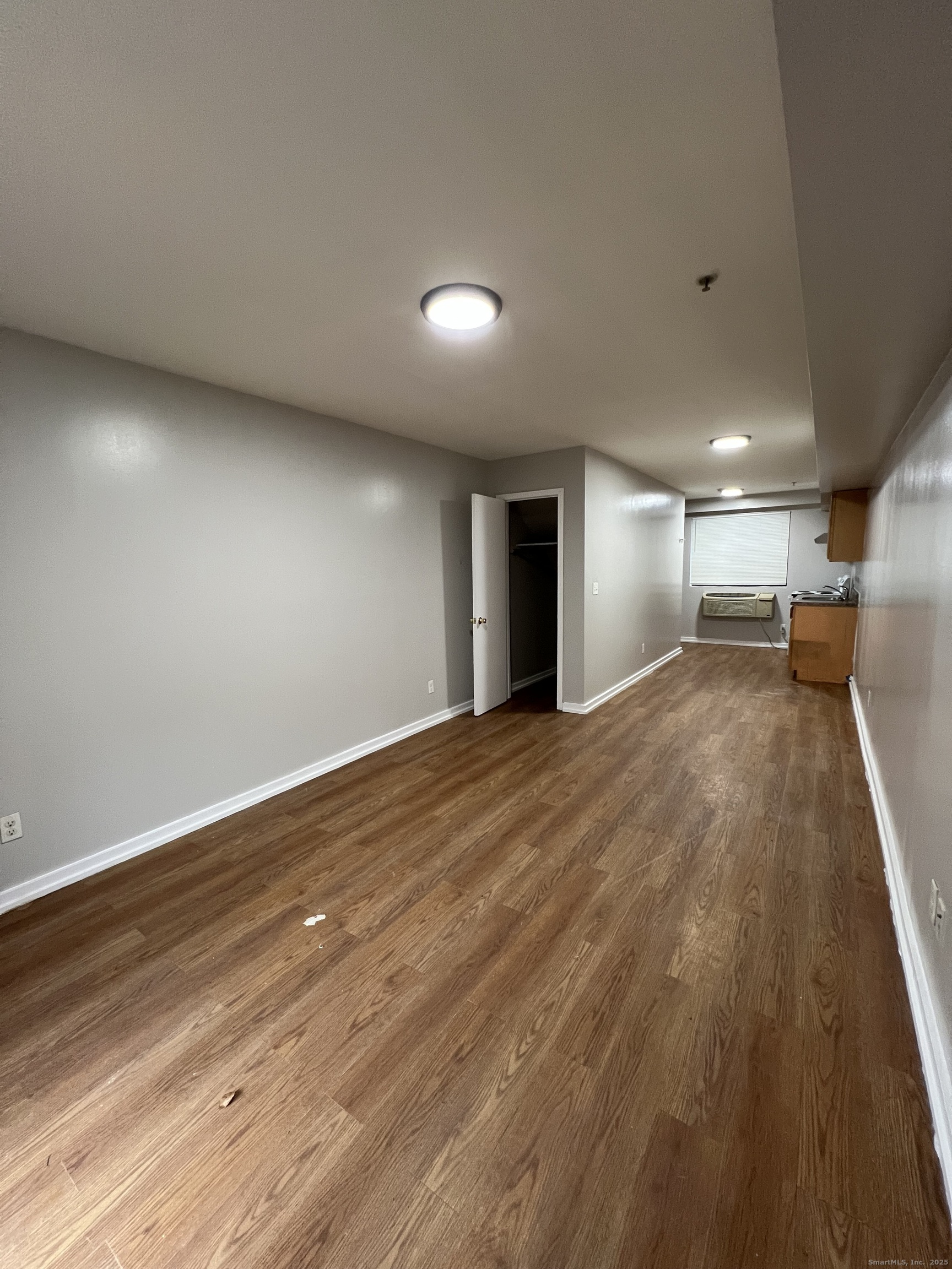 385 Putnam Avenue, Unit 35 Hamden, CT 06517 - Photo 3 of 17 an empty room with wooden floor and windows