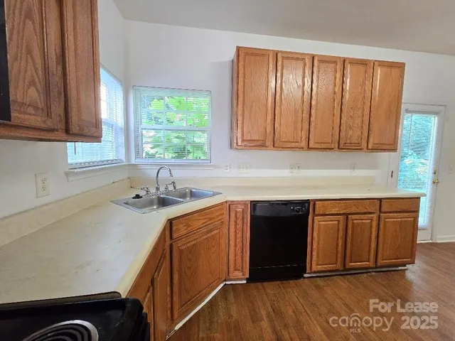 a kitchen with stainless steel appliances granite countertop wooden cabinets a sink and a window