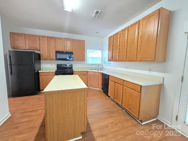 a kitchen with wooden cabinets a sink and a stove