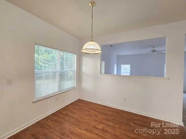 a view of a room with wooden floor and windows