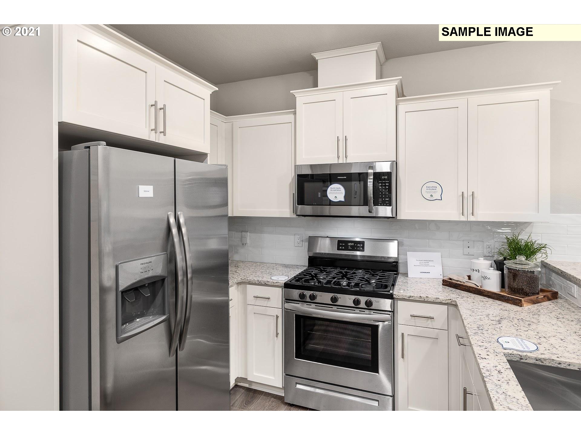 4260 South Laughing Water Circle Ridgefield, WA 98642 - Photo 2 of 24 a kitchen with stainless steel appliances white cabinets a sink and a stove