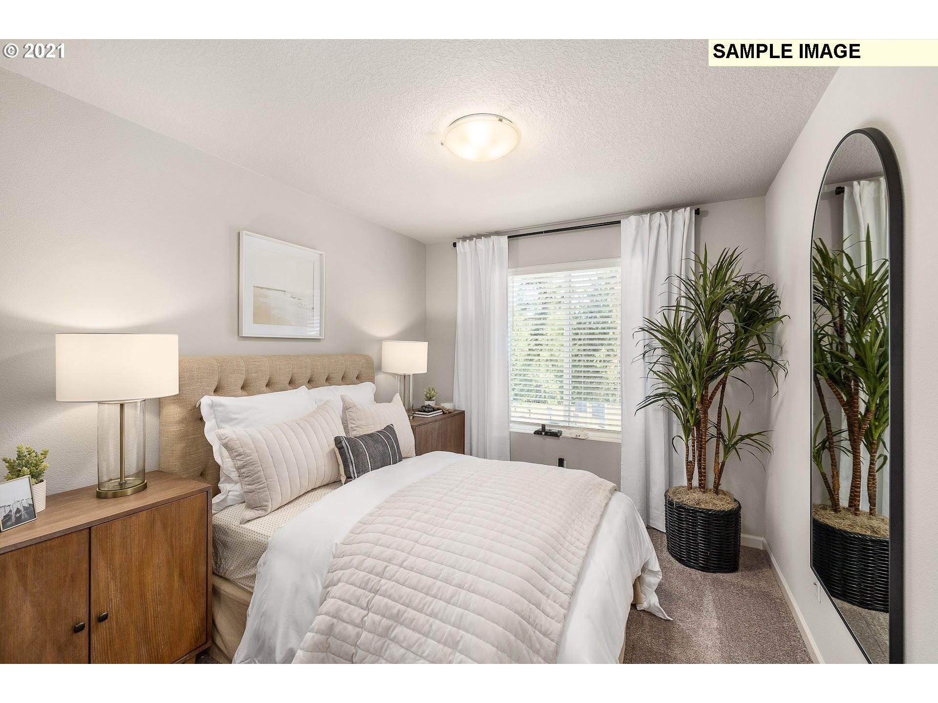 4260 South Laughing Water Circle Ridgefield, WA 98642 - Photo 12 of 24 a bedroom with a large bed and a potted plant