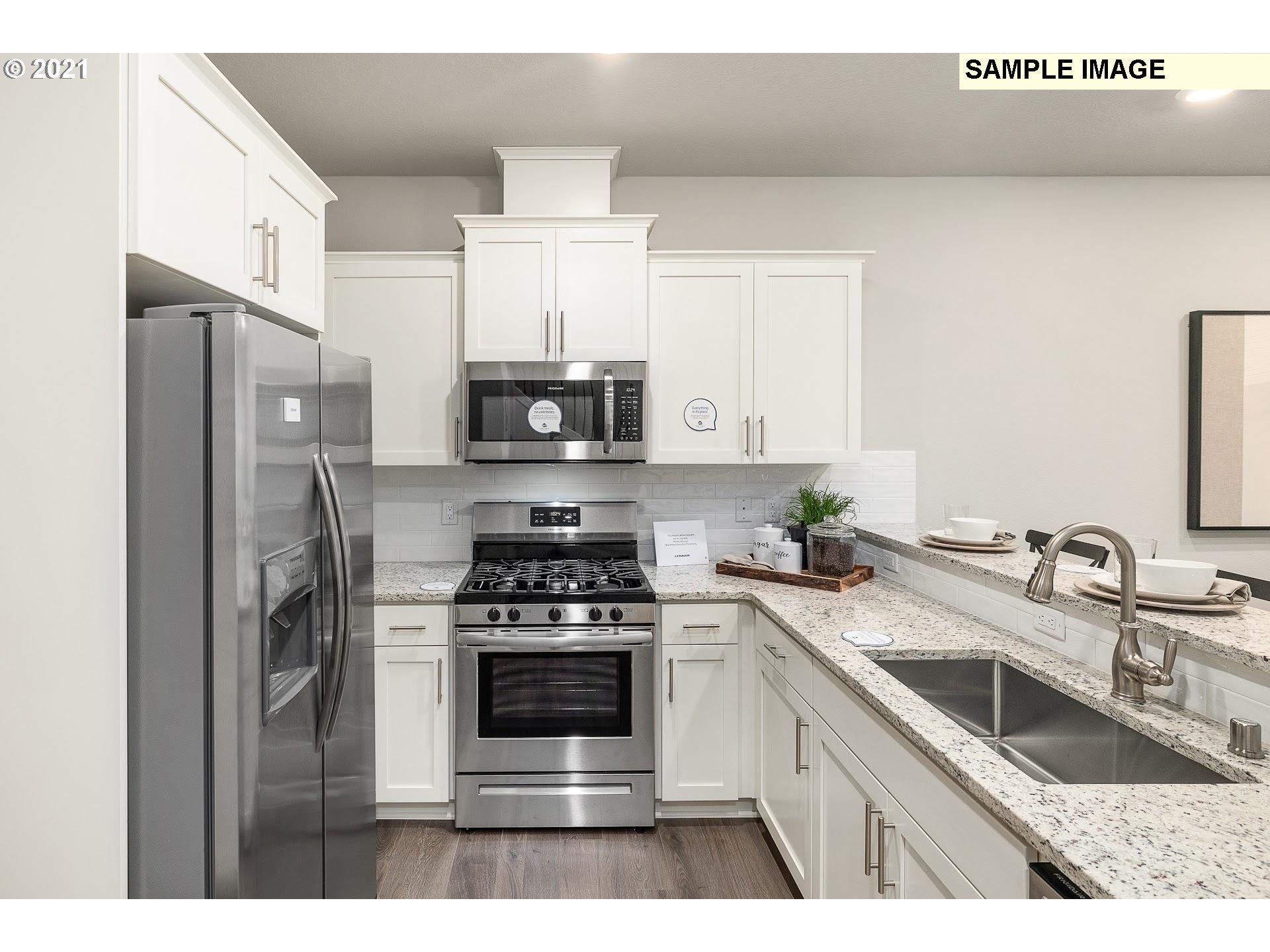4260 South Laughing Water Circle Ridgefield, WA 98642 - Photo 3 of 24 a kitchen with stainless steel appliances a sink stove and refrigerator