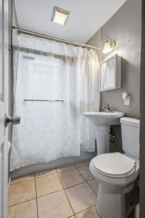a bathroom with a toilet a sink and a shower