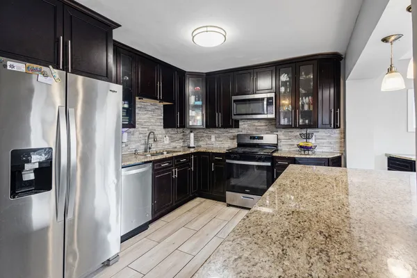a kitchen with stainless steel appliances granite countertop a refrigerator stove and oven