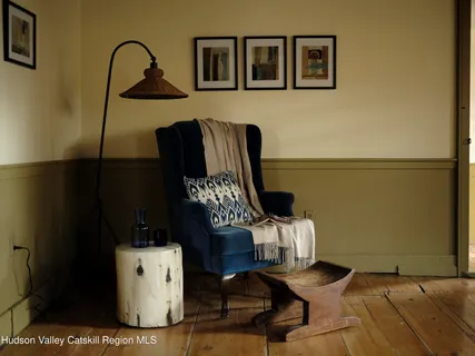 a bedroom with a bed and a lamp on dresser