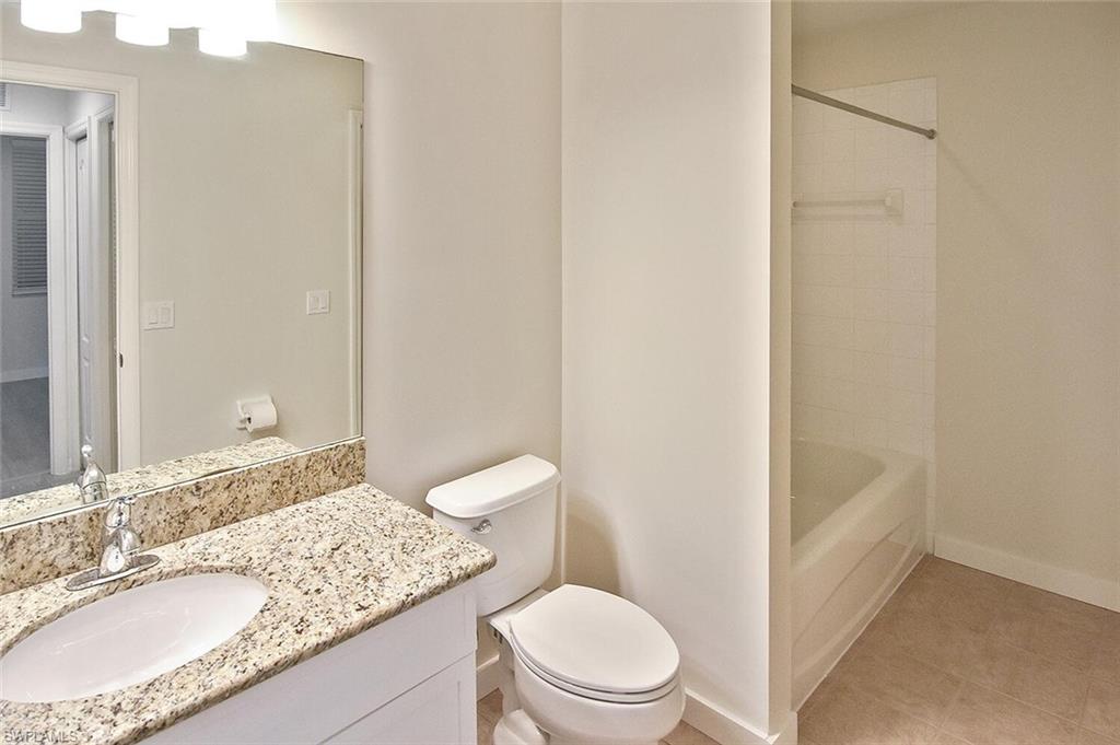 3830 Sawgrass Way, Unit 2914 Naples, FL 34112 - Photo 13 of 50 a bathroom with a granite countertop sink a toilet a mirror and shower