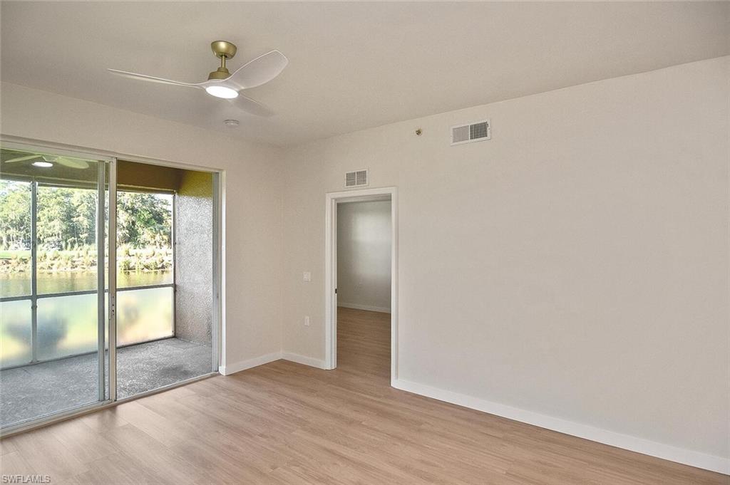 3830 Sawgrass Way, Unit 2914 Naples, FL 34112 - Photo 17 of 50 an empty room with wooden floor and windows