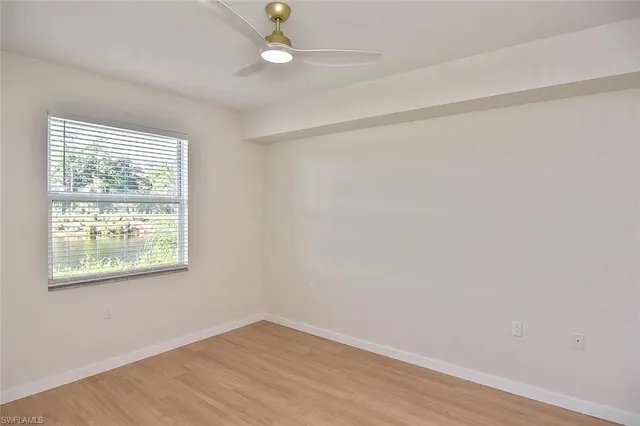 an empty room with a window and wooden floor