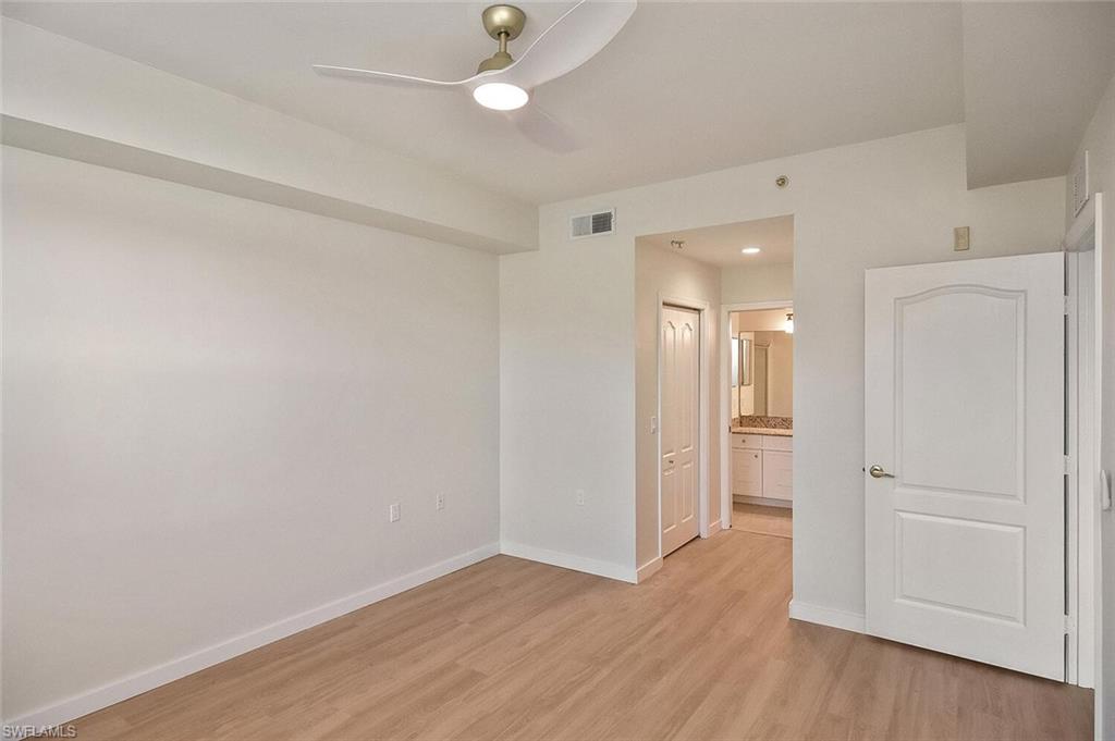 3830 Sawgrass Way, Unit 2914 Naples, FL 34112 - Photo 19 of 50 an empty room with wooden floor and windows