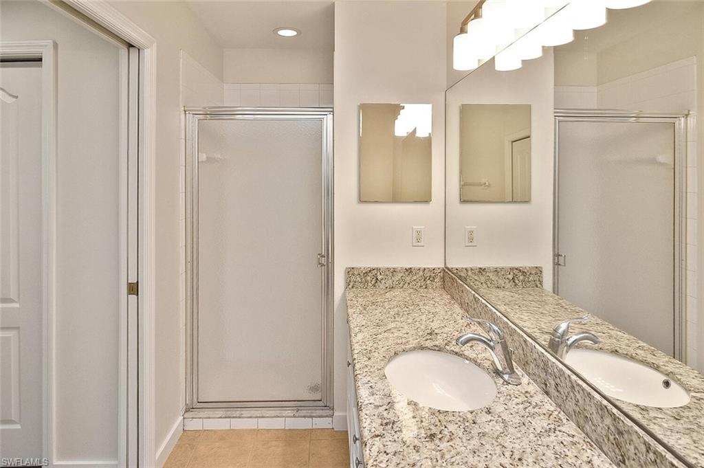 3830 Sawgrass Way, Unit 2914 Naples, FL 34112 - Photo 22 of 50 a bathroom with a granite countertop sink and a mirror