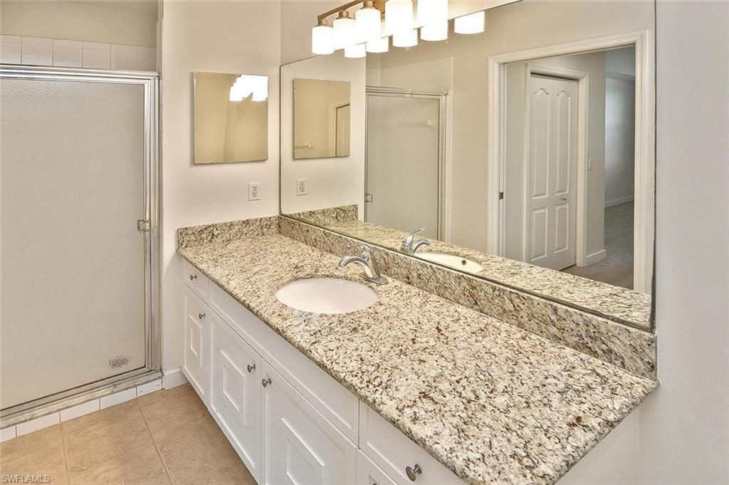 3830 Sawgrass Way, Unit 2914 Naples, FL 34112 - Photo 23 of 50 a bathroom with a granite countertop sink and a mirror