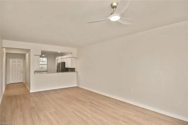 a view of a kitchen with wooden floor and a ceiling fan
