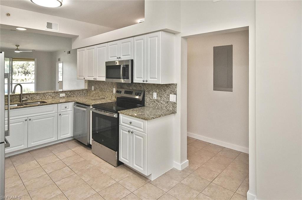 3830 Sawgrass Way, Unit 2914 Naples, FL 34112 - Photo 31 of 50 a kitchen with a sink stove and cabinets