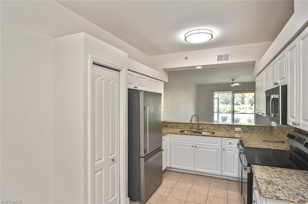 3830 Sawgrass Way, Unit 2914 Naples, FL 34112 - Photo 32 of 50 a large white kitchen with a sink and dishwasher a refrigerator with white cabinets