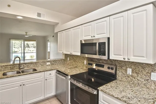 a kitchen with stainless steel appliances granite countertop a sink stove and cabinets
