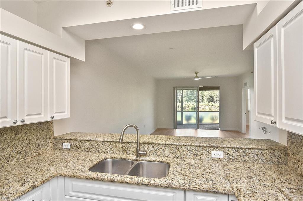3830 Sawgrass Way, Unit 2914 Naples, FL 34112 - Photo 35 of 50 a kitchen with granite countertop a sink window and cabinets
