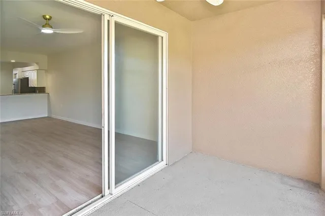 an empty room with wooden floor and a bathroom