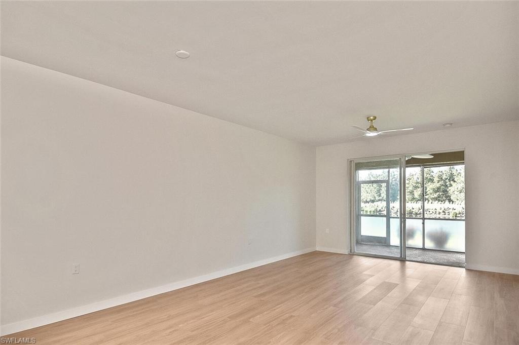 3830 Sawgrass Way, Unit 2914 Naples, FL 34112 - Photo 8 of 50 an empty room with wooden floor and windows