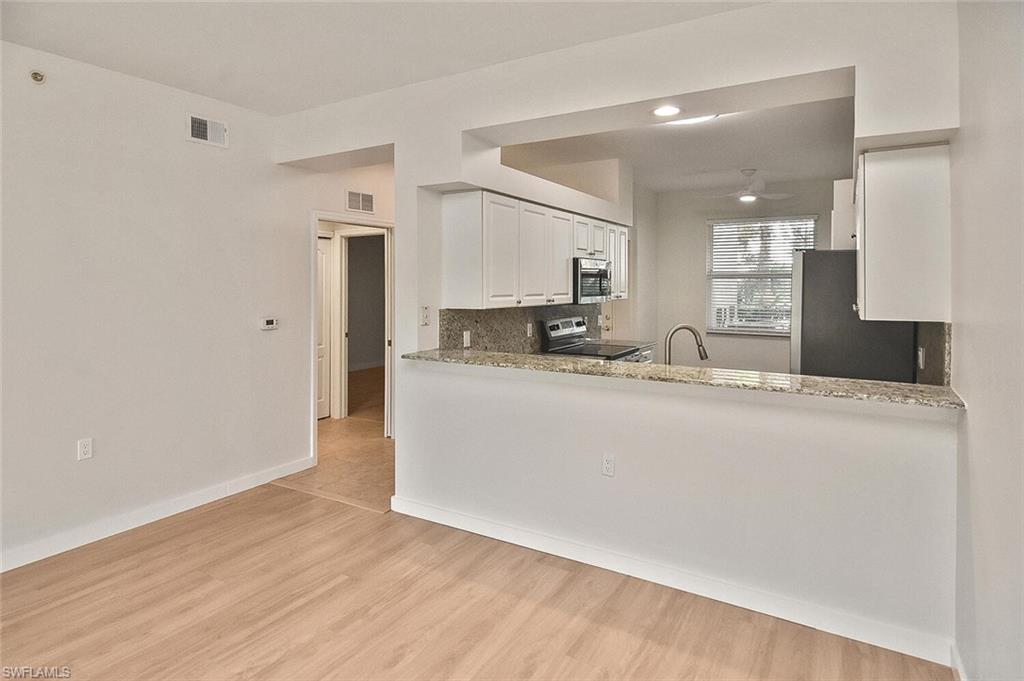 3830 Sawgrass Way, Unit 2914 Naples, FL 34112 - Photo 9 of 50 a room with kitchen island a sink and a refrigerator