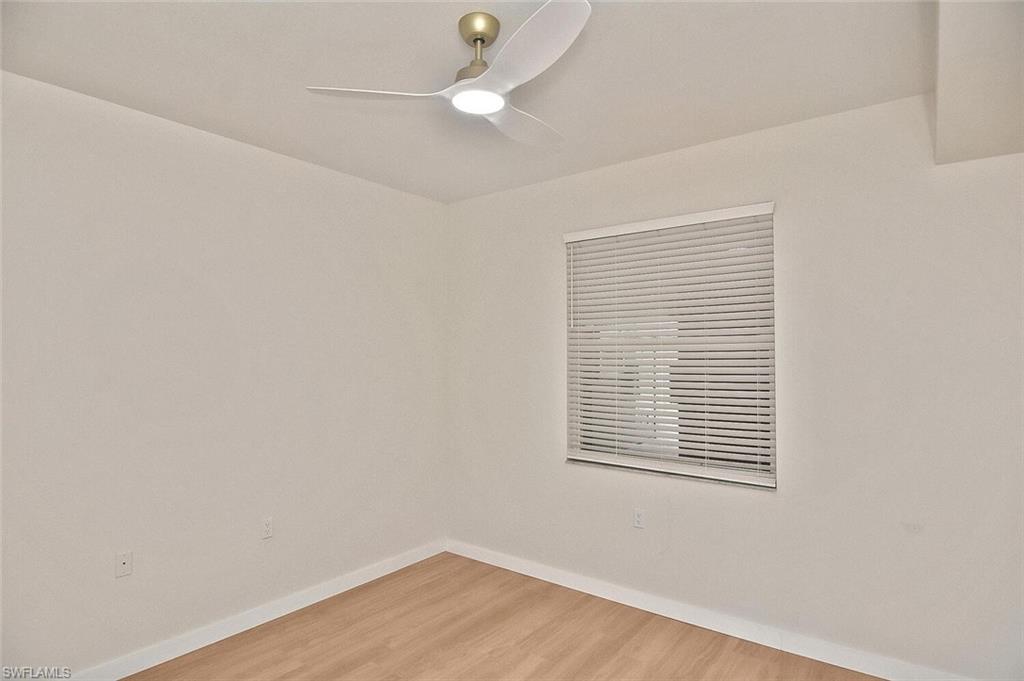 3830 Sawgrass Way, Unit 2914 Naples, FL 34112 - Photo 10 of 50 an empty room with a window and wooden floor
