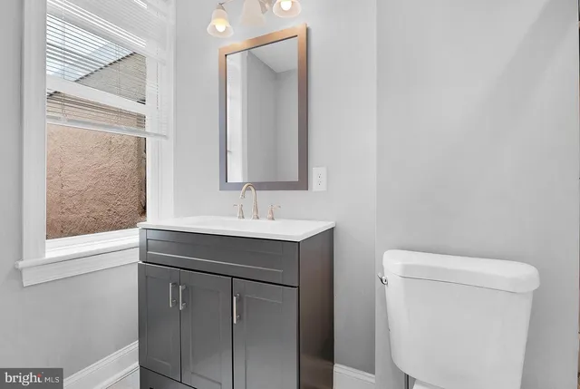 a bathroom with a sink toilet and mirror