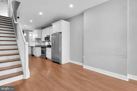a view of kitchen with stainless steel appliances refrigerator and wooden floor