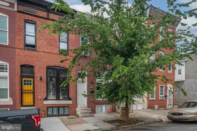 a front view of a building with trees