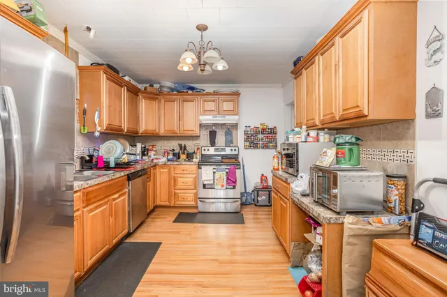 a kitchen with stainless steel appliances kitchen island granite countertop a refrigerator and a stove