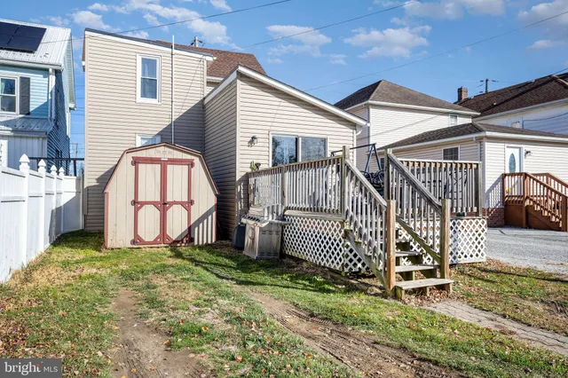 a view of a house with wooden fence and a porch