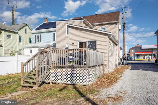 a view of a white house with wooden fence