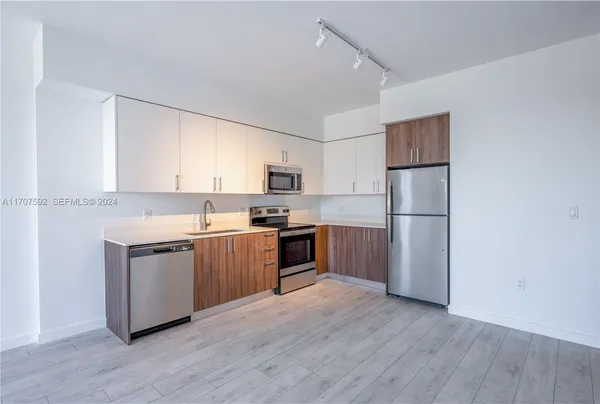 a kitchen with a refrigerator cabinets and wooden floor