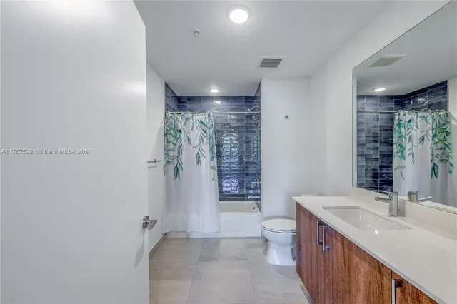 a bathroom with a double vanity sink toilet and shower