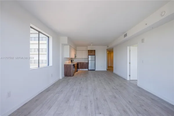 an empty room with windows and cabinet
