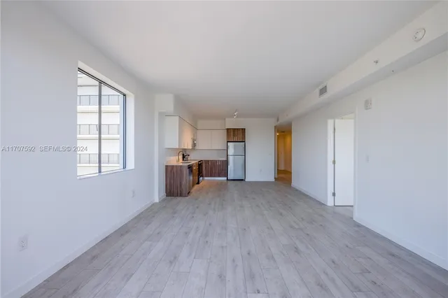 an empty room with windows and cabinet