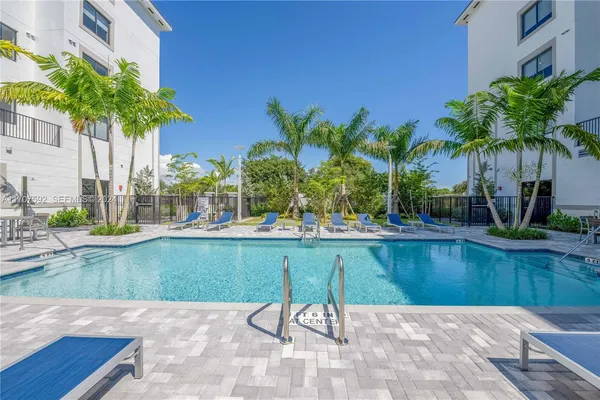a swimming pool with outdoor seating and garden