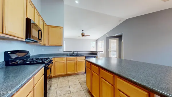 a kitchen with stainless steel appliances granite countertop a sink stove and cabinets