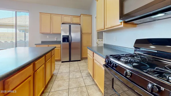 a kitchen with stainless steel appliances granite countertop a stove a refrigerator and a microwave