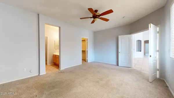a view of a livingroom with a ceiling fan & entryway