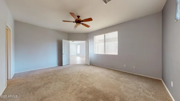 a view of a big room with windows and chandelier fan