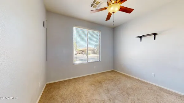 an empty room with a window and a ceiling fan
