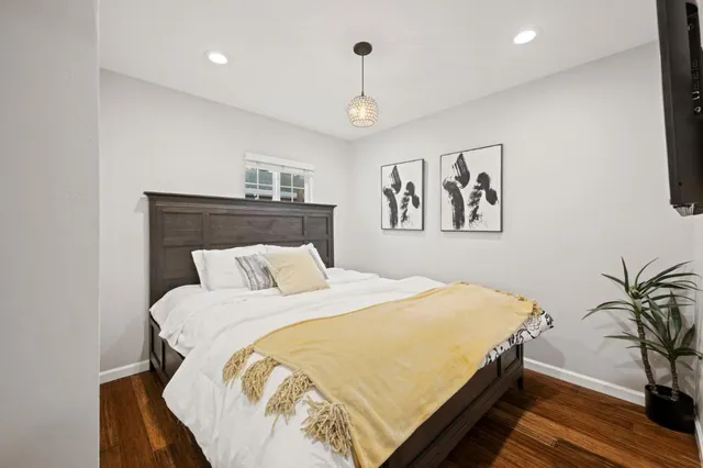a bedroom with a bed and wooden floor